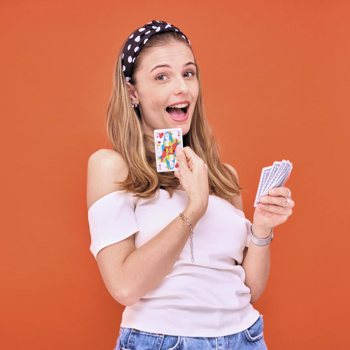 Photo d'une femme qui montre une carte de dame de cœur. 