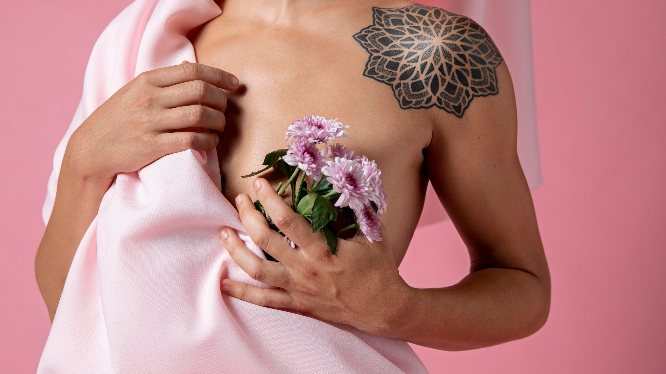 Photo d'un buste de femme dont la cicatrice de chirurgie mammaire est cachée par un bouquet de fleurs. 