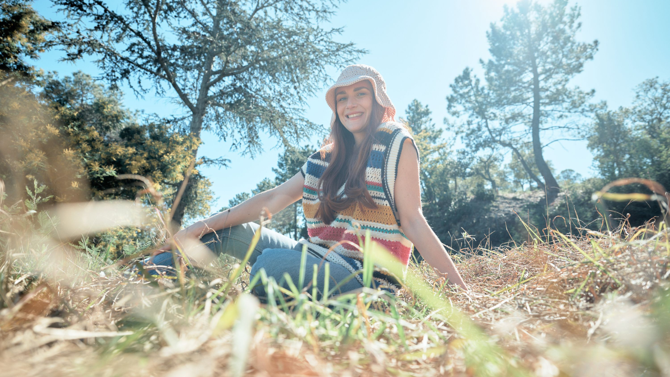 Photo d'une femme assise dans l'herbe. 