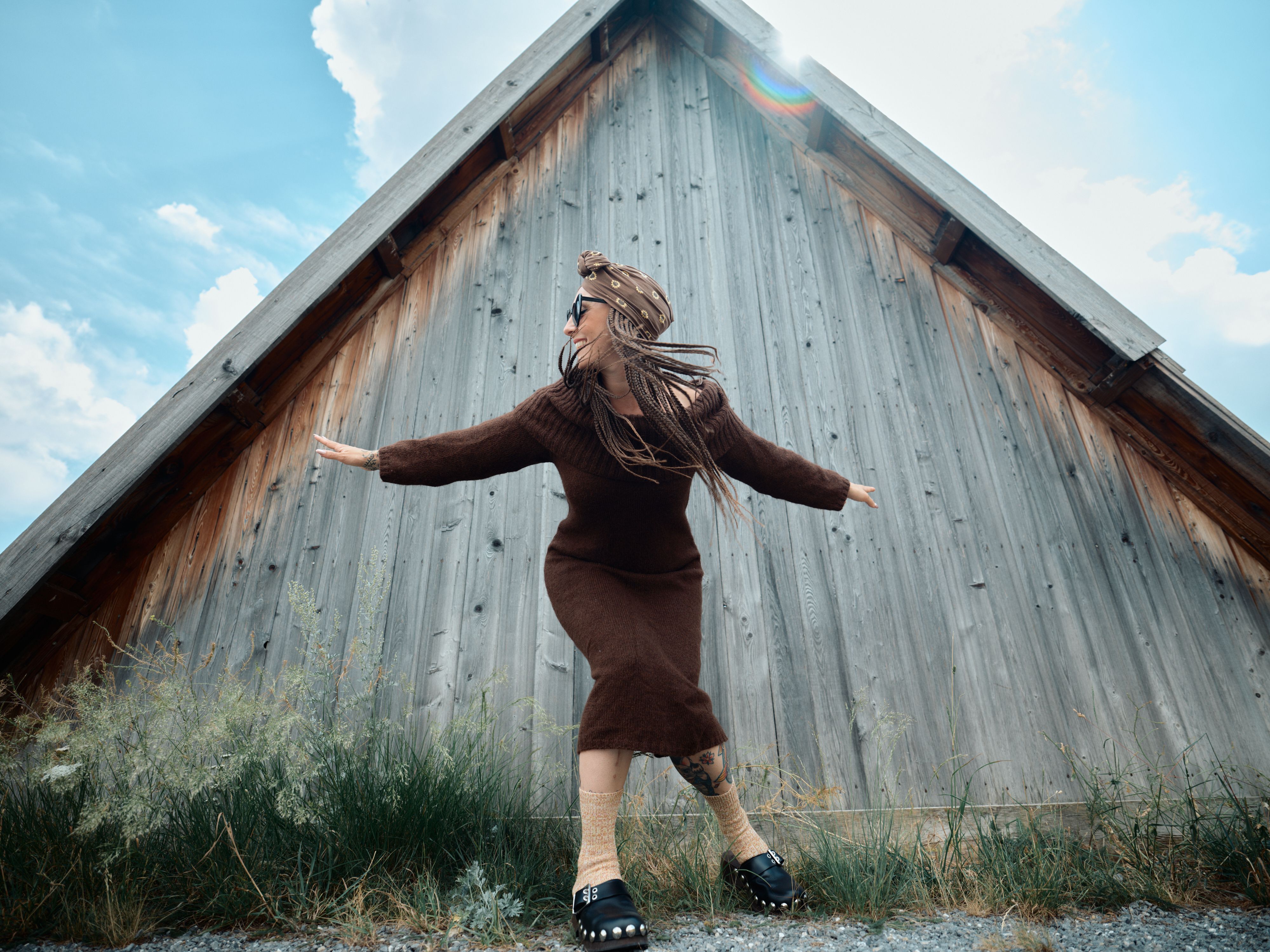 Photo de Julie qui porte une robe en laime marron et semble danser. 