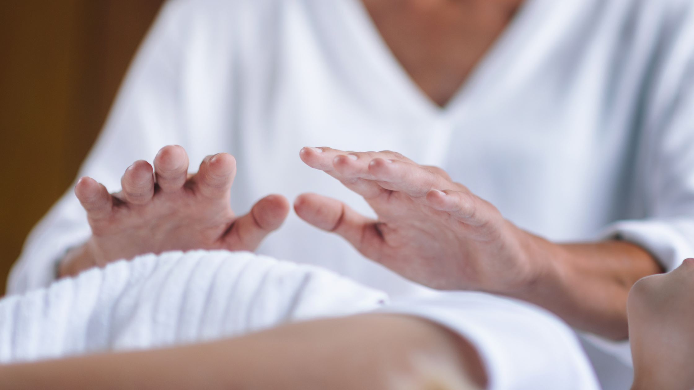 Phto d'un praticien Reiki dont les mains sont positionnées 10 cm au-dessus du thorax d'un patient. 