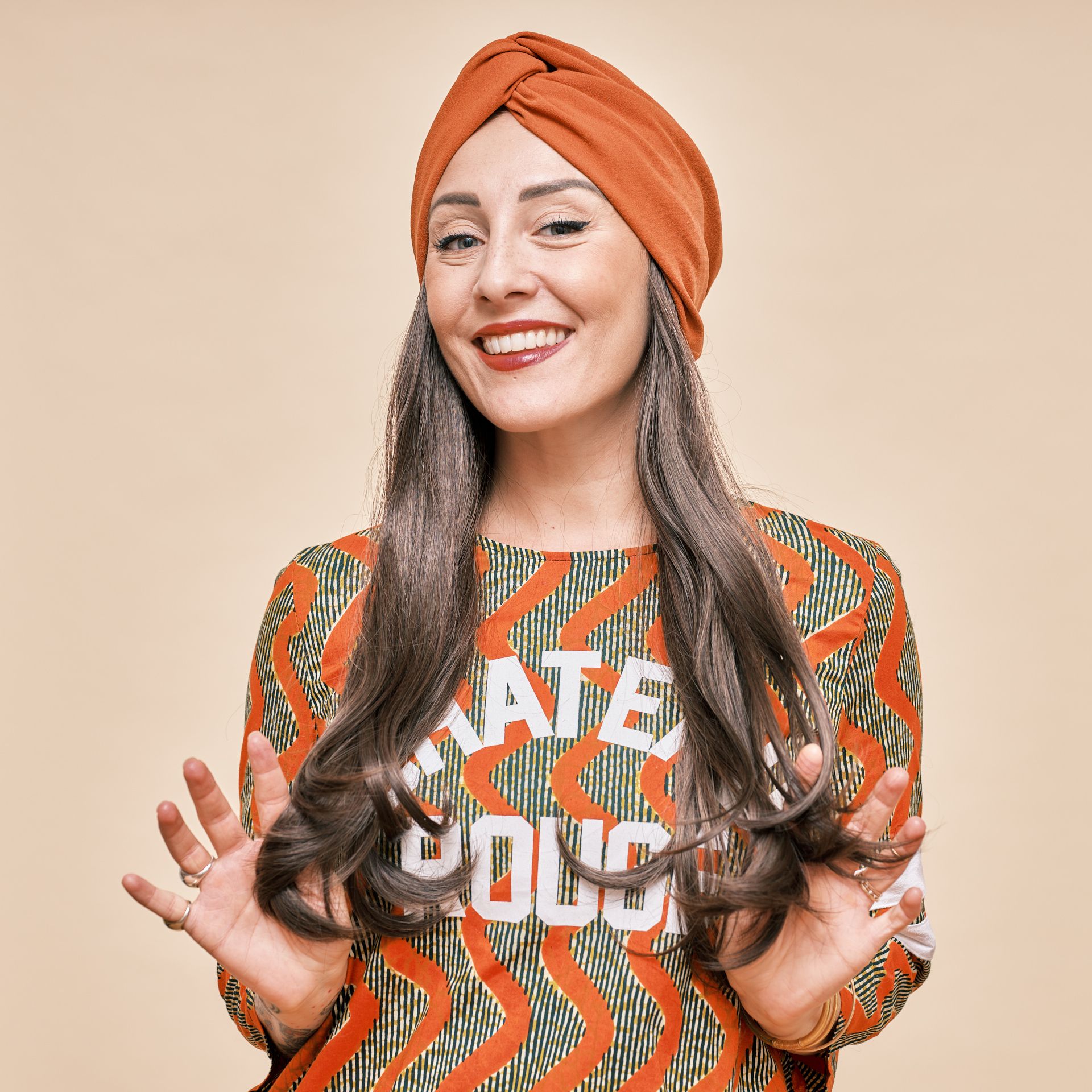 Photo de Julie qui porte une couronne de cheveux et un magnifique bonnet orange. 