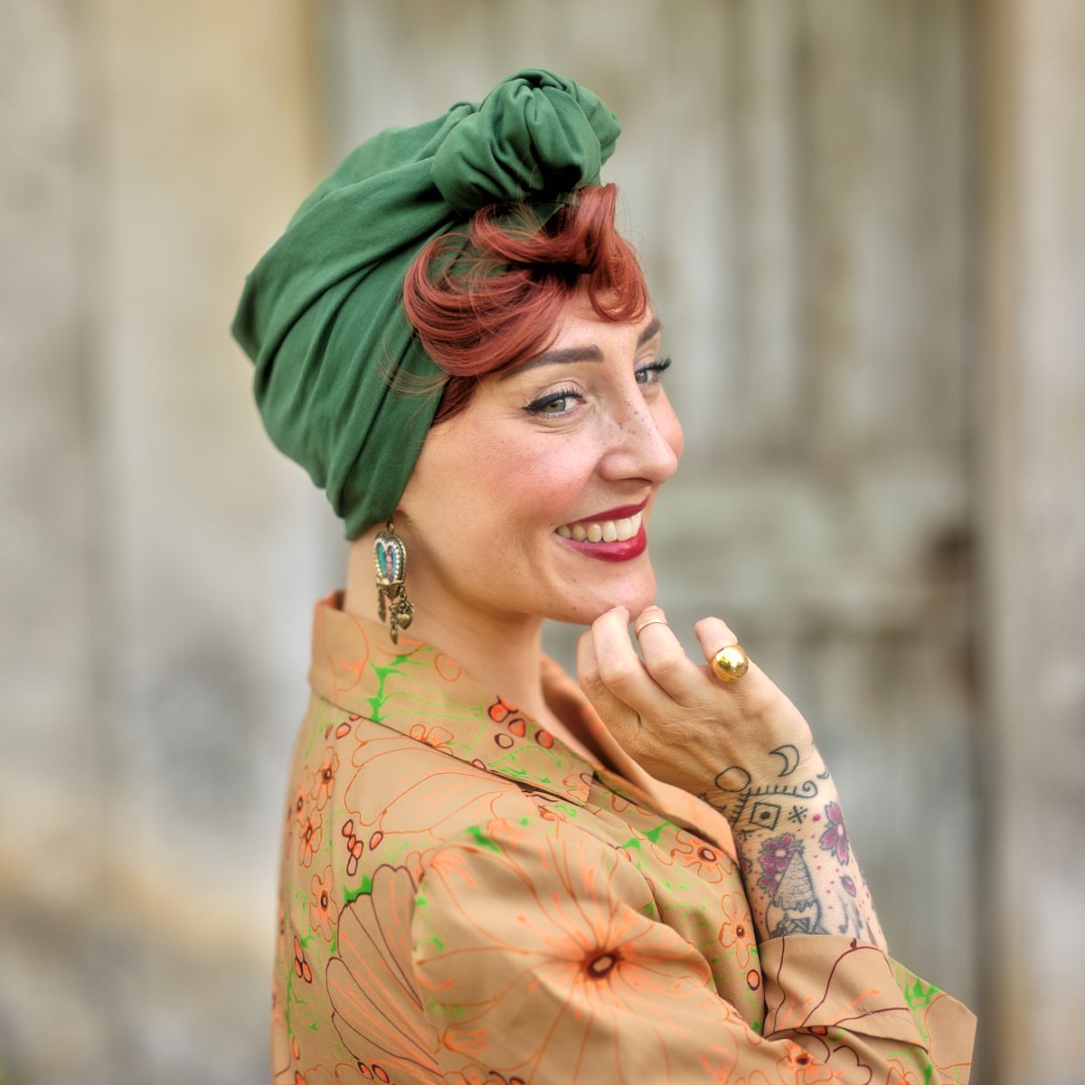 Photo de Julie qui porte une frange rousse et un turban vert. 